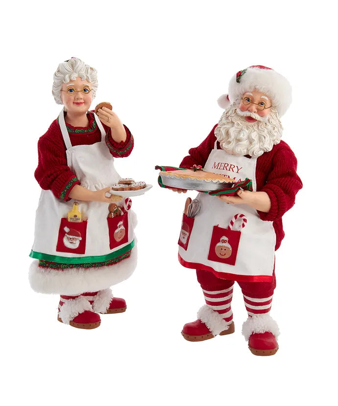 Mr and Mrs Claus figurines in baker aprons holding cookies and a pie, set of two.