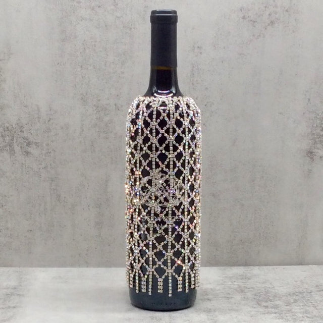 Silver rhinestone veil draped over a wine bottle.