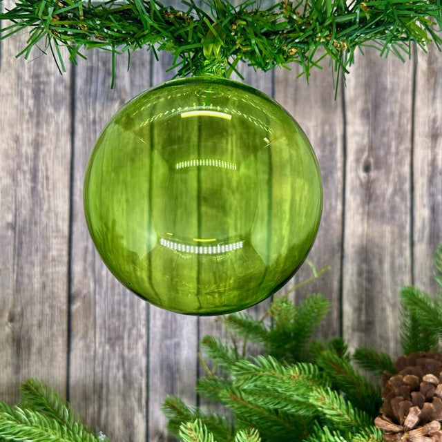 Bright green glass ball ornament with a luminous finish.