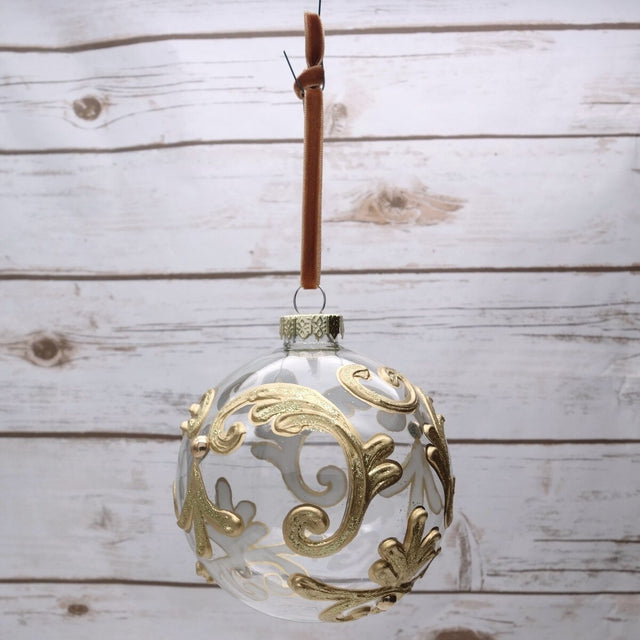 Gold leaf glass ball ornament with a leafy pattern.