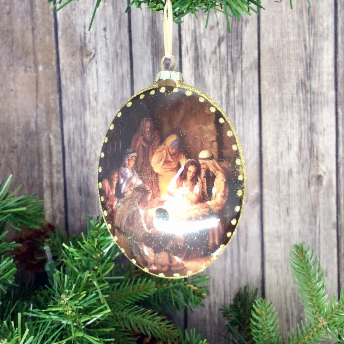 Glass ornament with holy family glass oval detail.