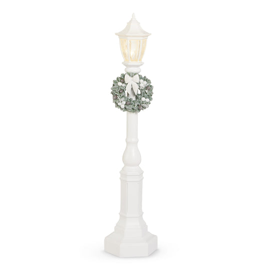 White lamp post with wreath and red bow