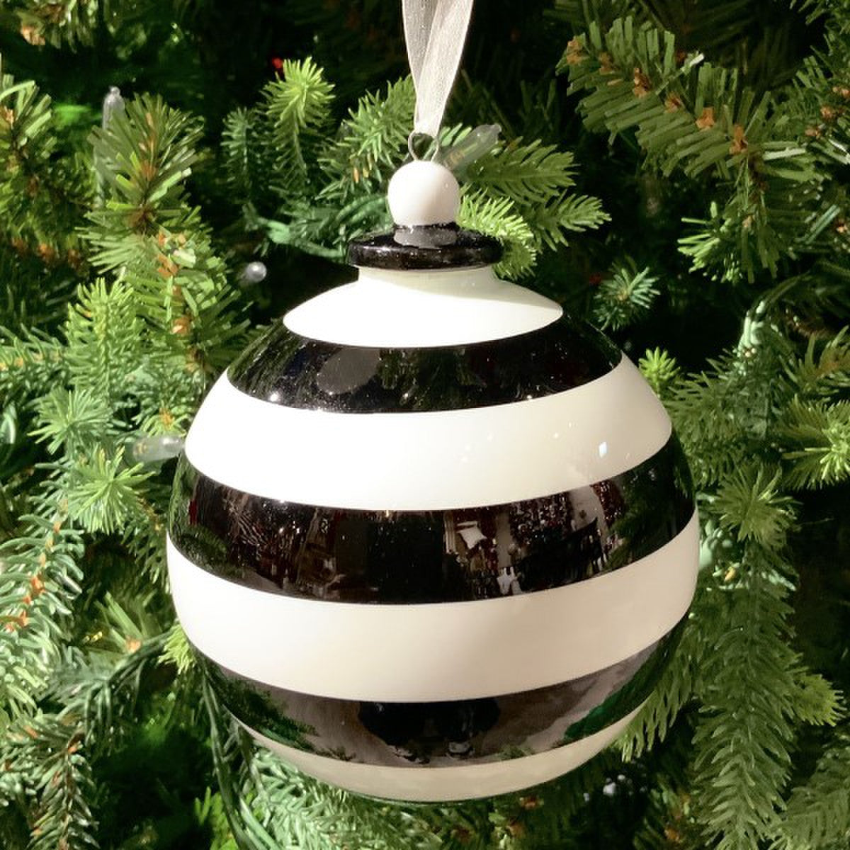 Black ball ornament with bold stripes in black and white.