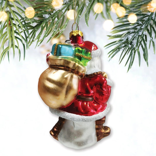 Red glass Santa ornament, back view of the gold sack topped with wrapped gifts, styled among pine branches.
