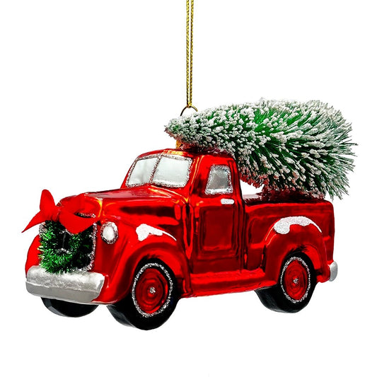 Red glass pickup truck ornament with a frosted Christmas tree in the bed and a wreath on the grille.
