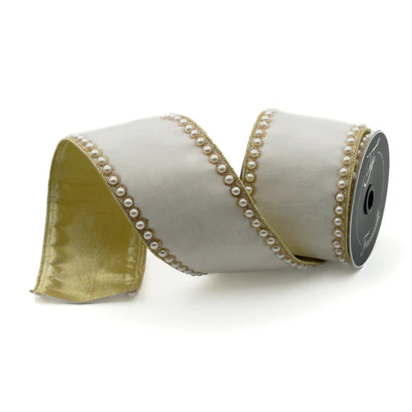 Ivory velvet ribbon with pearl borders on a spool.