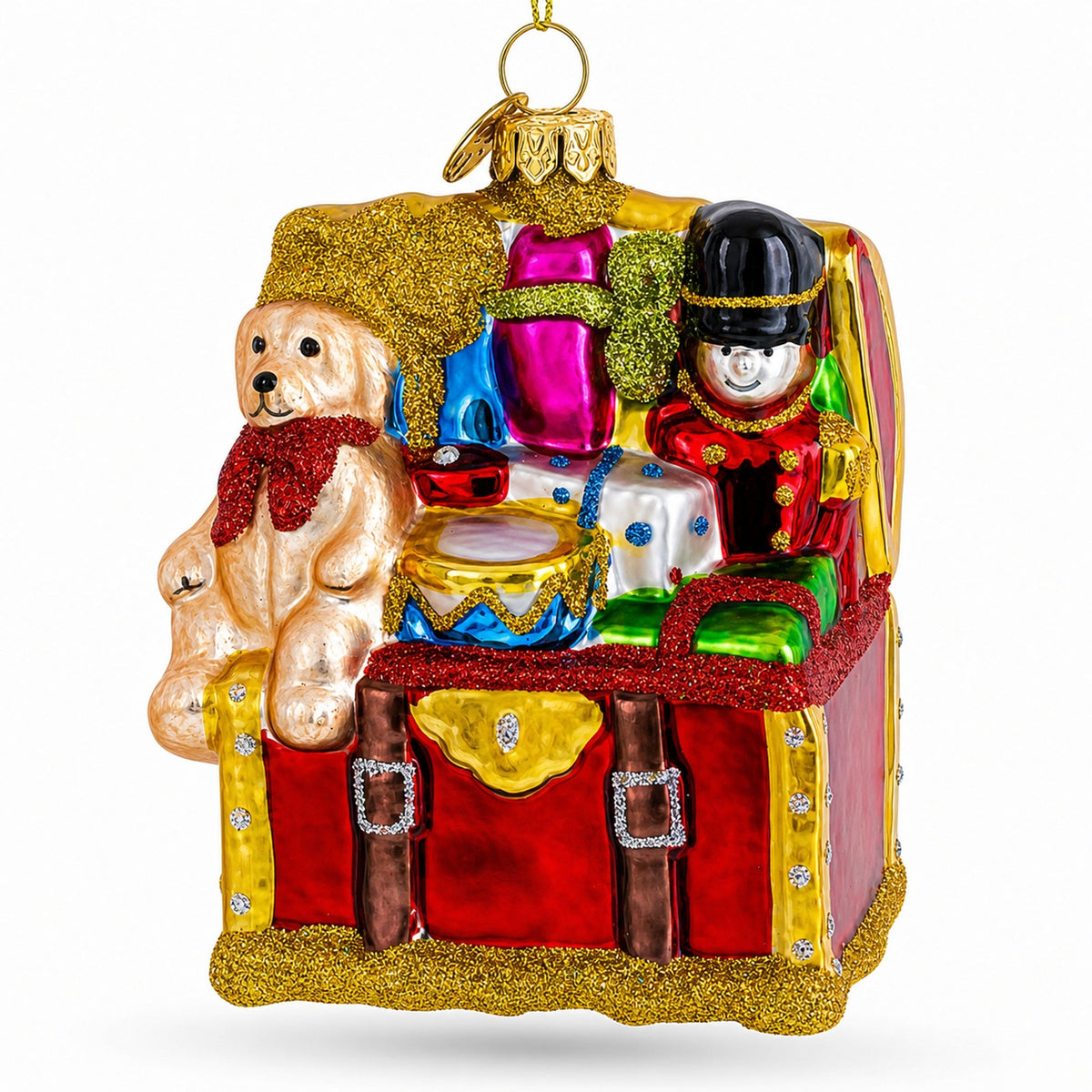 Red glass toy trunk ornament with a teddy bear, toy soldier and drum spilling out.