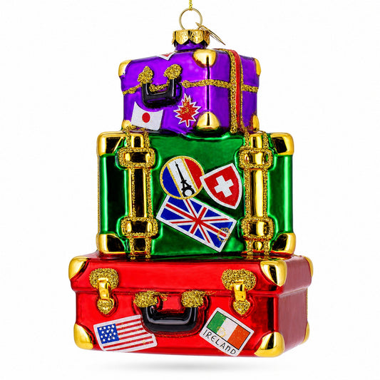 Multicolored glass luggage ornament with stacked suitcases and travel stickers.