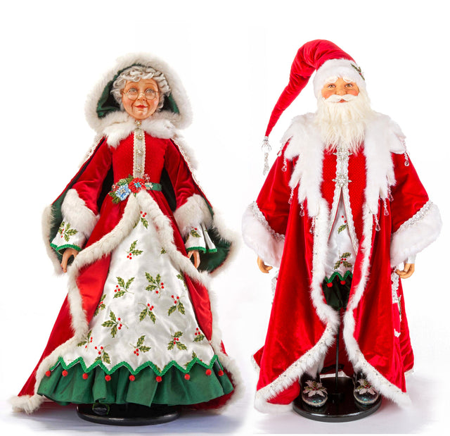 Mrs. Santa and Santa figures in red velvet coats with white fur trim and holly embroidery.